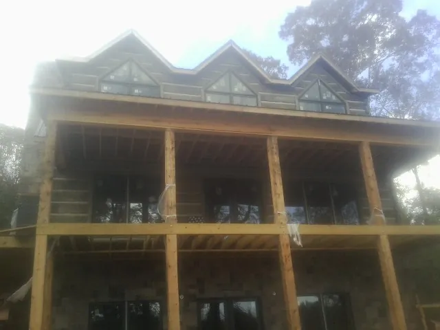 Dormers and porch framing on a large log home under construction — Roof Coating work by our crew in Richton Park